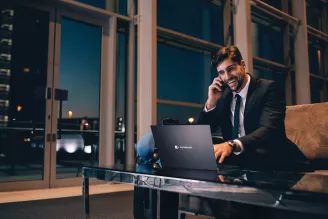 Businessman using laptop on phone at night