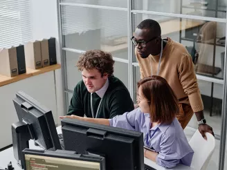 Work colleagues discussing content on PC screen