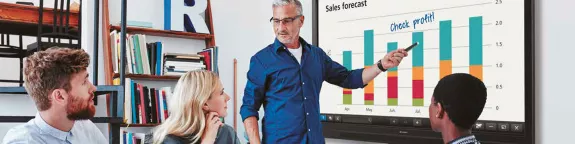 Three people in a meeting using an interactive whiteboard